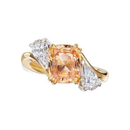 Gold ring with a large orange gemstone and smaller diamond gemstones on a white background