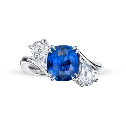 Silver ring with a blue gemstone and two smaller diamonds on a white background