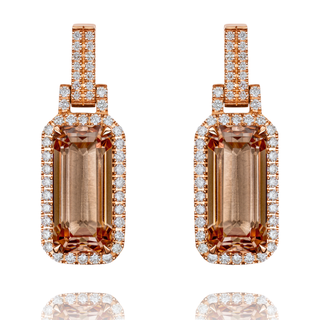 Pair of rose gold earrings with brown gemstones on a white background