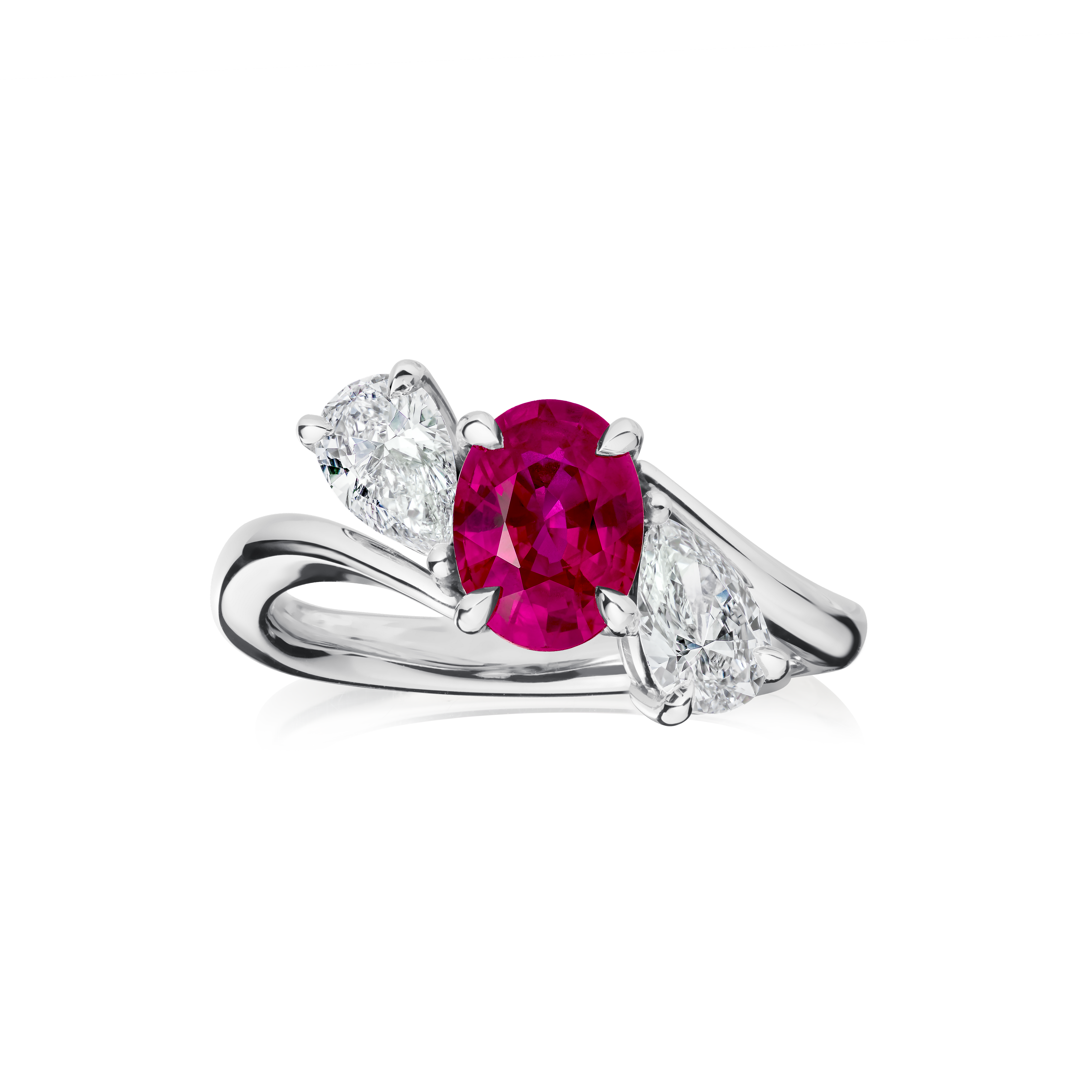 Silver ring with a red gemstone and two white gemstones on a white background