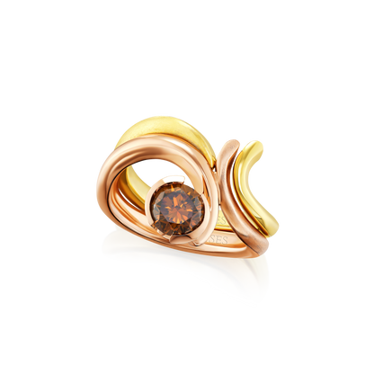 Gold and rose gold ring with a brown gemstone on a white background