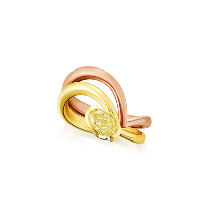 Three gold rings with a central yellow gemstone on a white background