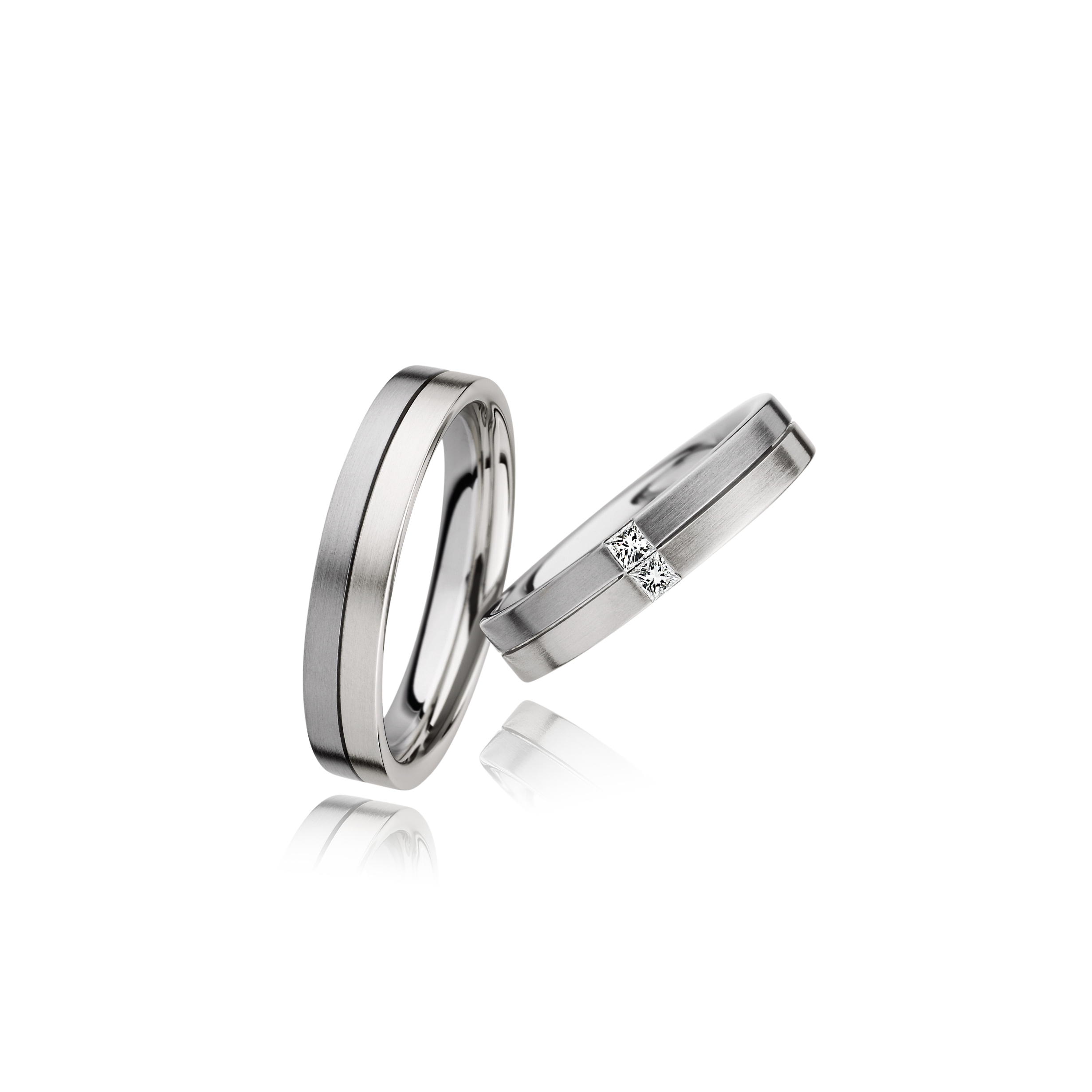 Two silver rings with a diamond on a white background