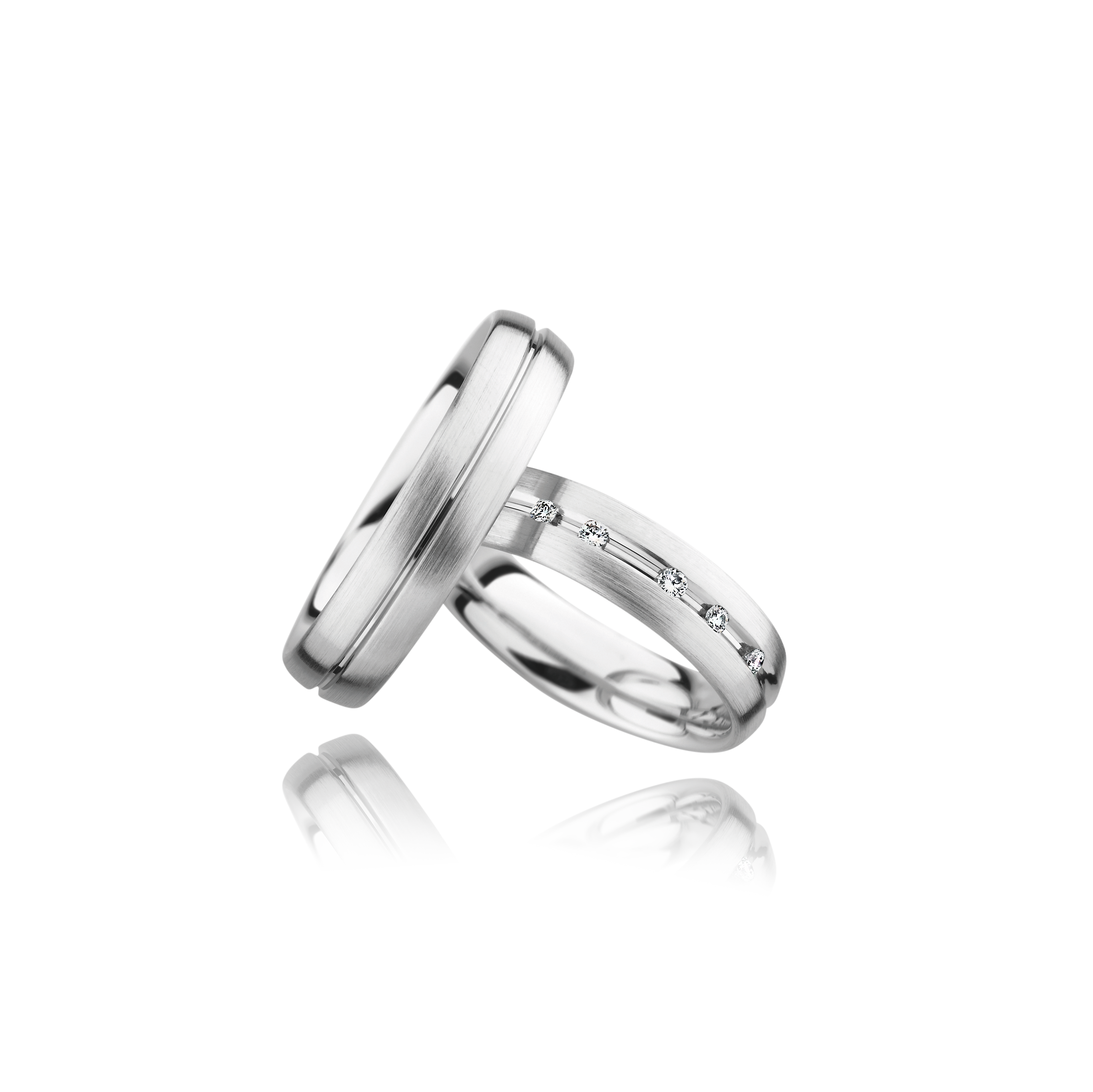 Two silver rings with engraved designs on a white background