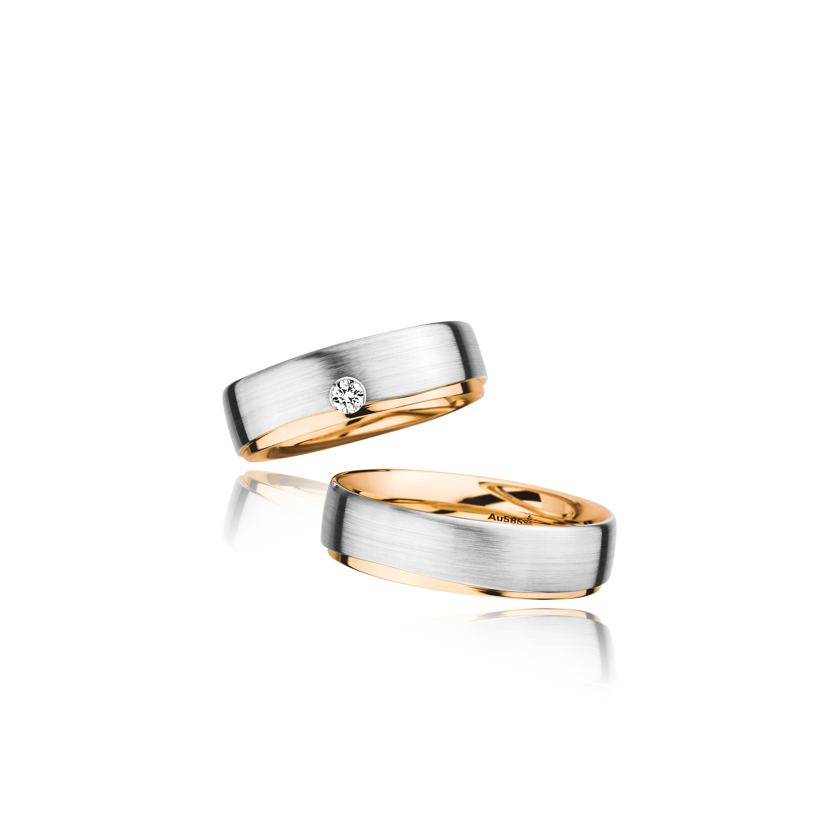 Two gold wedding bands with a diamond on a white background