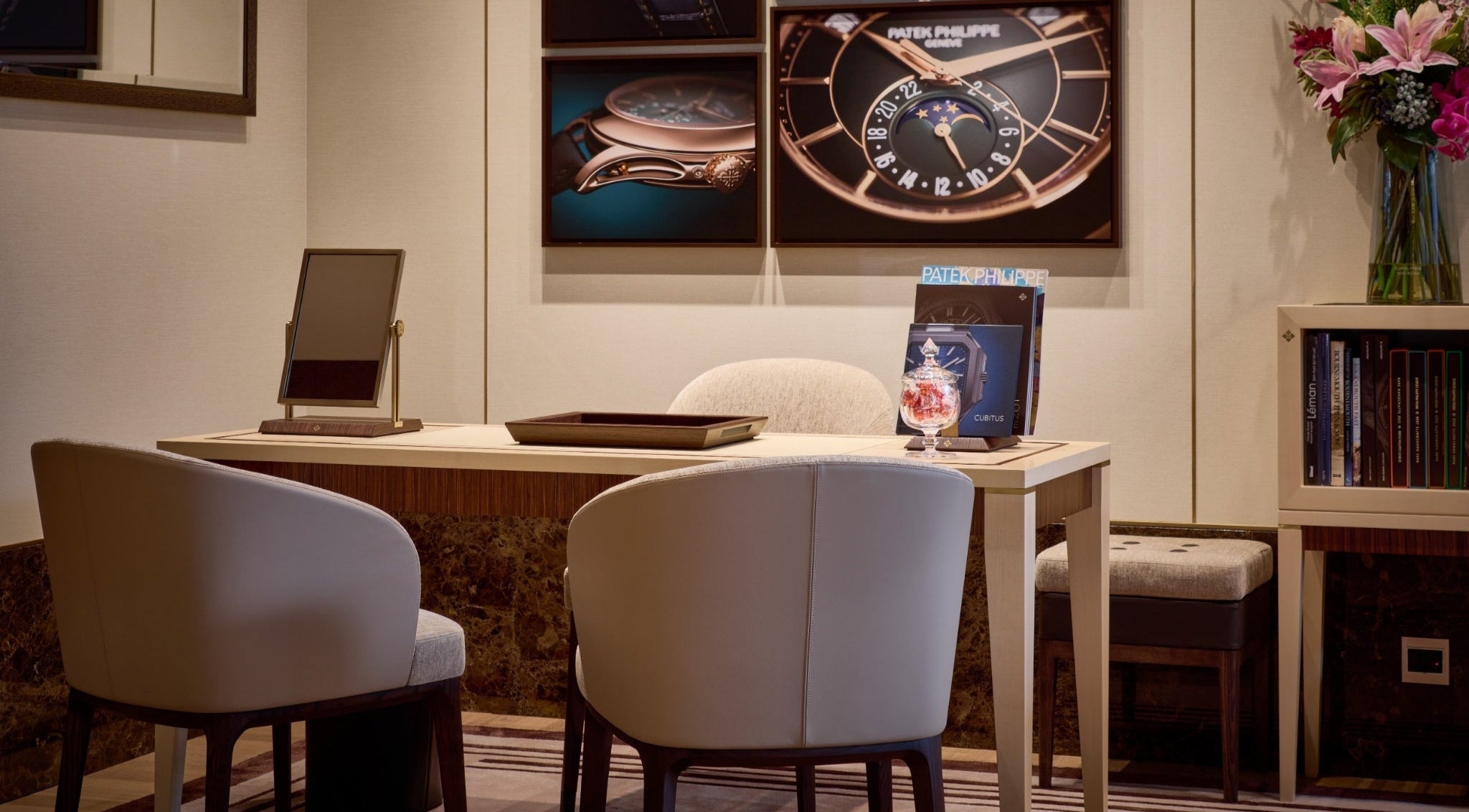 Patek Philippe showroom Bournemouth with a desk, chairs, and wall art displaying watches.